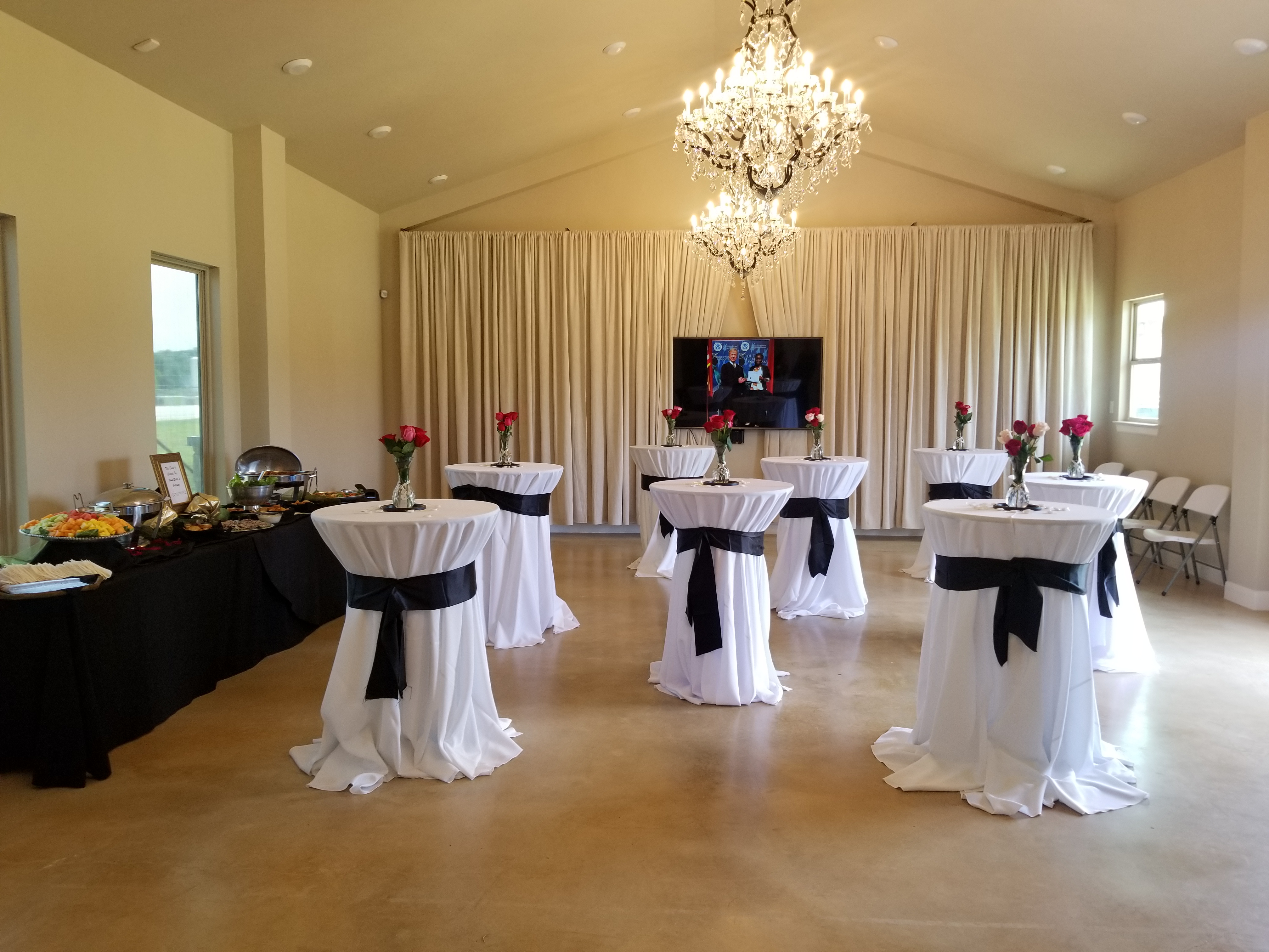 Kai-Simone Winery event room with cocktail tables, black sashes, floral centerpieces and crystal chandelier