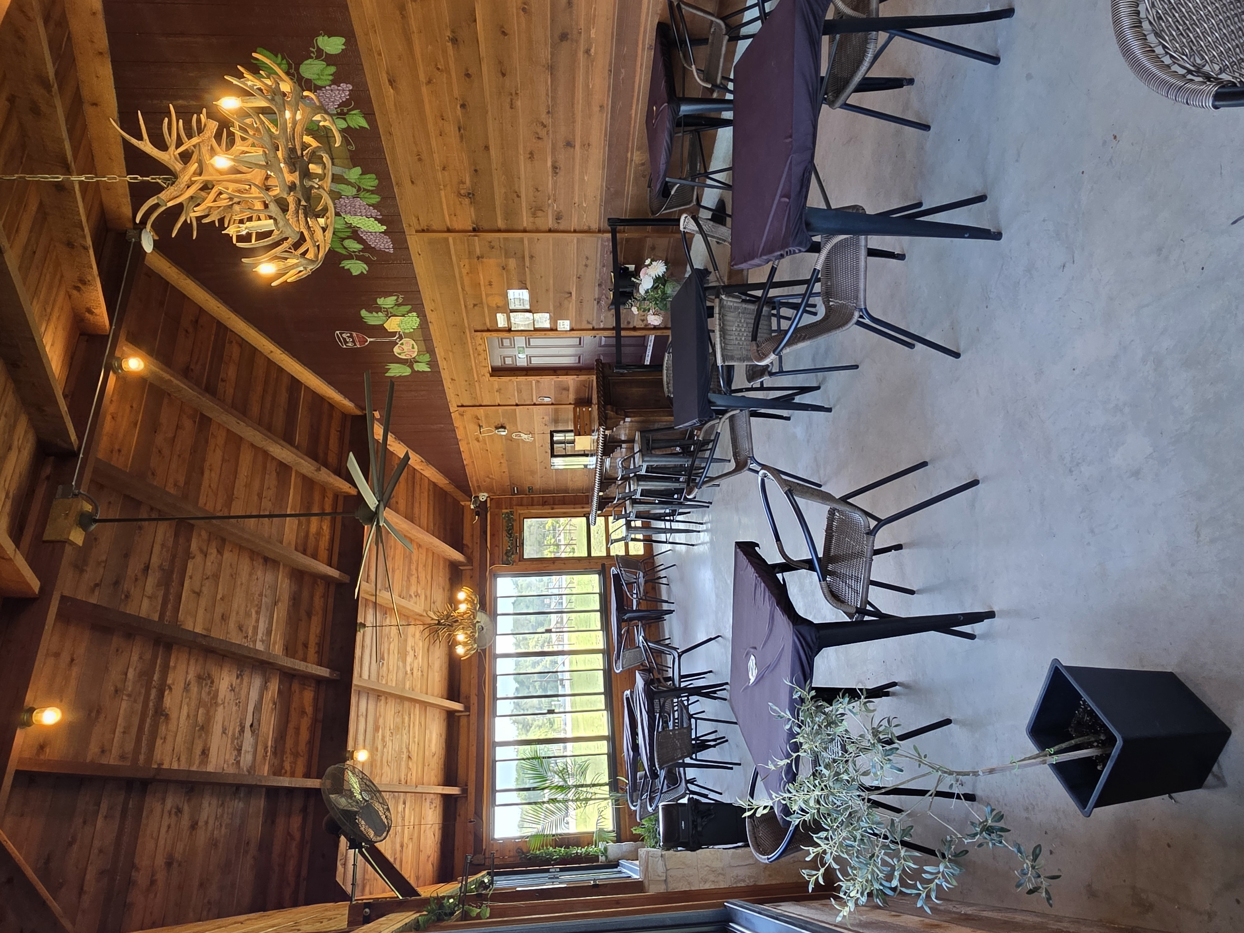 Kai-Simone Winery pavilion dining area with antler chandelier, wood walls and plum tablecloths