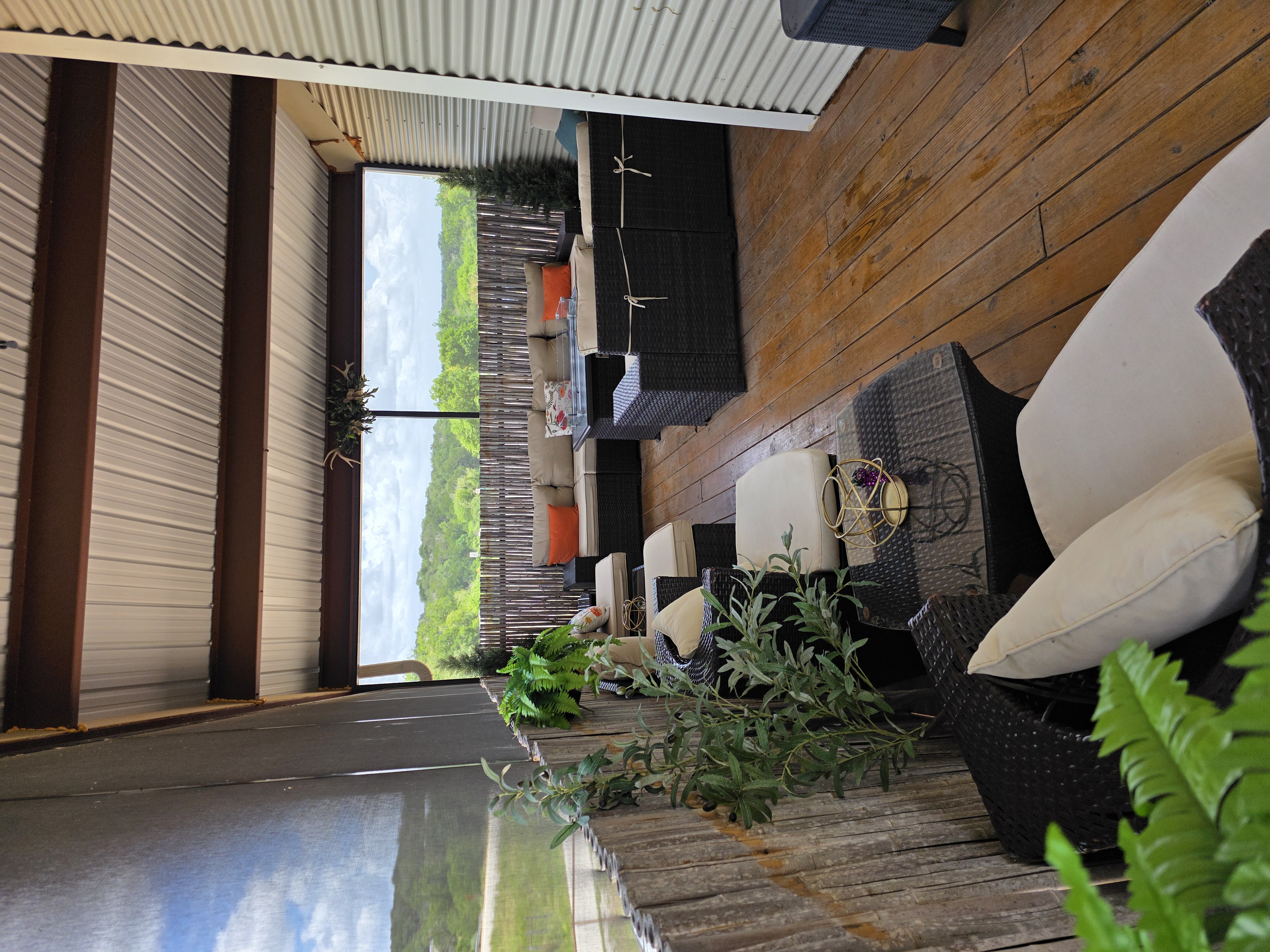 Kai-Simone Winery screened balcony interior with wicker lounge seating, wood plank floor and Hill Country views