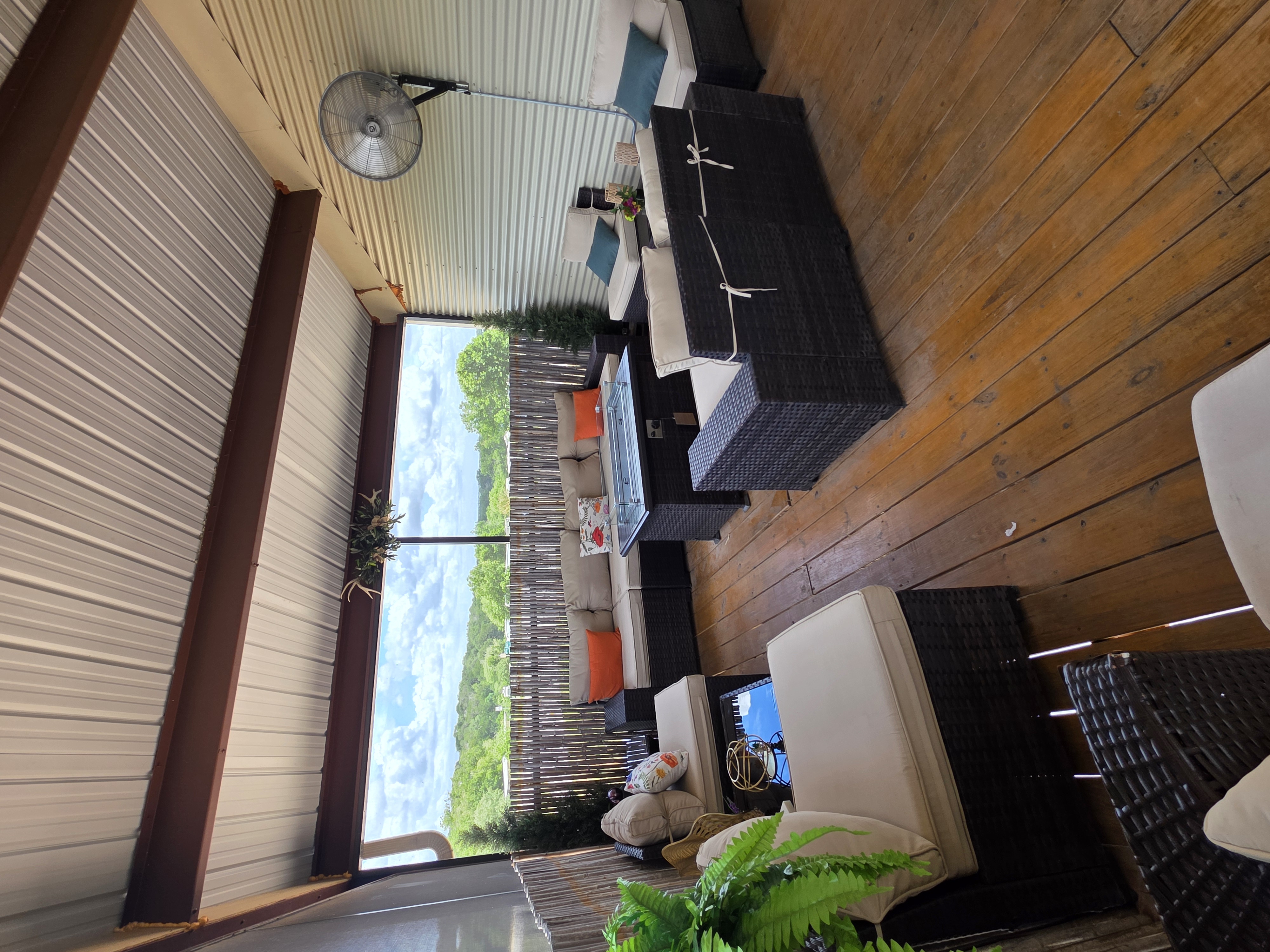 Kai-Simone Winery screened balcony with wicker sofas, orange accent pillows and panoramic Hill Country views